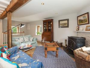 a living room with a couch and a fireplace at Rhydleos Mill in Llansilin