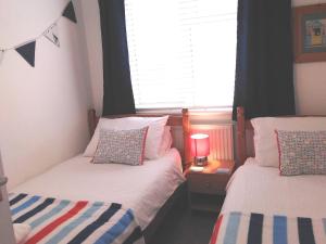 two twin beds in a room with a window at Sweet Briar in Newquay +9 photos