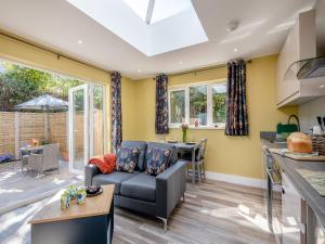 a kitchen and living room with a couch and a table at Peacock Lodge in Thurlton