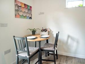 a dining room table with two chairs and a painting at Coley Cottage in Wainfleet All Saints