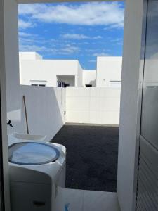 ein Badezimmer mit Toilette auf einem Balkon in der Unterkunft Casa nova para alugar no bairro zona norte in Capão da Canoa