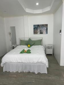 a bedroom with a white bed with flowers on it at Agape Suites-Room 2-Ground Floor in Soufrière