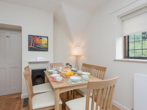 a dining room with a table and chairs with food on it at Stable Yard Cottage in Selborne