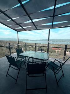 einen Tisch und Stühle auf einer Terrasse mit Aussicht in der Unterkunft Chalet de montaña in Villa Carlos Paz