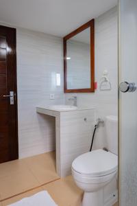 a bathroom with a toilet and a sink and a mirror at Blue Oceana Villa in Nusa Dua