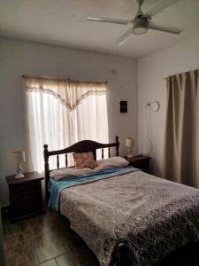 ein Schlafzimmer mit einem Bett und einem Deckenventilator in der Unterkunft Flor silvestre in Carpintería