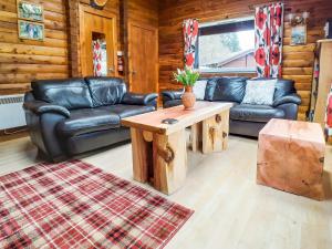 a living room with leather couches and a coffee table at Ard Darach Lodge in Dunoon