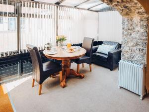a dining room with a table and chairs and a couch at The Corn Store - Uk6716 in Lydstep
