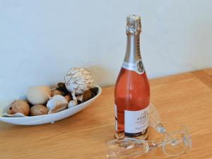 a bottle of wine on a table with a bowl of shells at The Corn Store - Uk6716 in Lydstep
