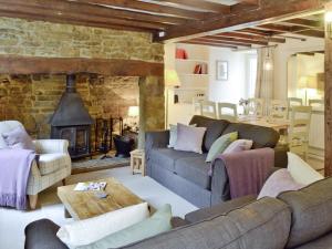 ein Wohnzimmer mit zwei Sofas und einem Kamin in der Unterkunft The Old Sweet Shop in Hook Norton