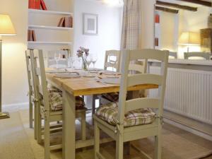 einem Esstisch mit 2 Stühlen und einem Tisch mit Weingläsern in der Unterkunft The Old Sweet Shop in Hook Norton + 14 Fotos