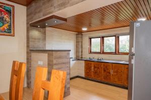 a kitchen with wooden cabinets and a stainless steel refrigerator at Blue Oceana Villa in Nusa Dua