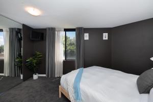 a bedroom with a large bed with black walls at Griffin 165 in Kingston 