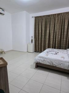 a white bedroom with a bed and a window at غرف فندقيه - بدع زايد in Bū Rays