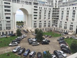 un montón de autos estacionados en un estacionamiento frente a un edificio en Batumi Magnolia, en Batumi