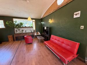 a living room with a red couch in a green wall at Loft acogedor en el campo in Putaendo