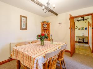 a dining room table with a vase of flowers on it at Rafters Barn - E2064A in Runcton Holme