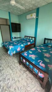 two beds sitting next to each other in a room at Hotel Los Nogales Coveñas in Coveñas