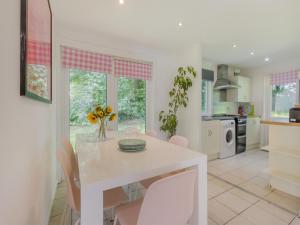 a white dining room with a table and chairs at Keepers Wood - W43109 in Bradworthy