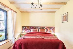 a bedroom with a bed with a red blanket at Melissa Wasi in Pisac