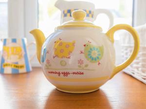 a tea pot with cats painted on it on a table at The Old Shippen - Uk48328 in Lifton