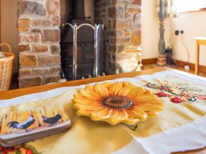 a sunflower is sitting on a table next to a plate at The Old Shippen - Uk48328 in Lifton