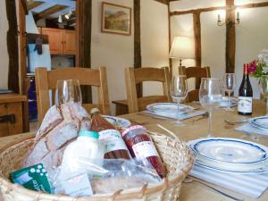 a table with a basket of bread and wine bottles at Meadow Cottage in Chediston