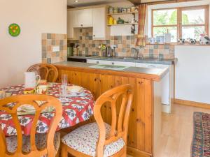 a kitchen with a table and chairs and a kitchen with a counter at The Old Shippen - Uk48328 in Lifton