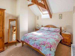 a bedroom with a bed and a dresser and a mirror at The Old Shippen - Uk48328 in Lifton +6 photos