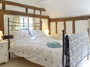 a bedroom with a bed with a blue towel on it at Meadow Cottage in Chediston +7 photos