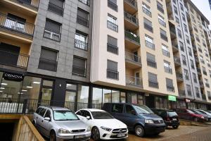 three cars parked in a parking lot in front of a building at Sweet Dreams Apartment in Pristina