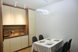 a dining room with a table with chairs and a sink at Sweet Dreams Apartment in Prishtinë