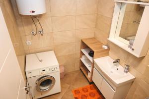 a small bathroom with a washing machine and a sink at Sweet Dreams Apartment in Pristina +8 photos