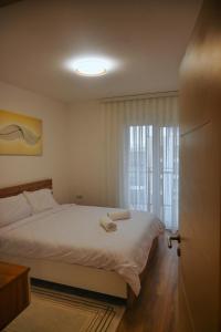a bedroom with a white bed and a window at Sweet Dreams Apartment in Pristina