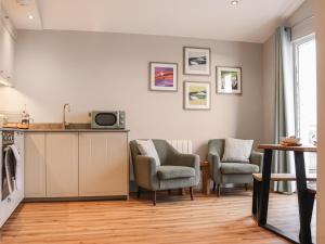 South Snowdon Wharf في بورثمادوج: مطبخ مع كرسيين وكاونتر وطاولة