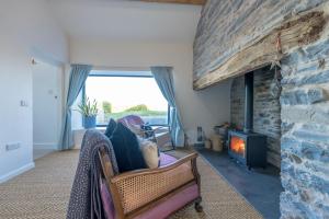 a living room with a stone fireplace and a couch at Petryal in Llangernyw
