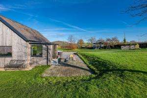 a barn with a picnic table next to a yard at Petryal in Llangernyw