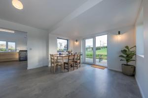 a dining room and kitchen with a table and chairs at Petryal in Llangernyw