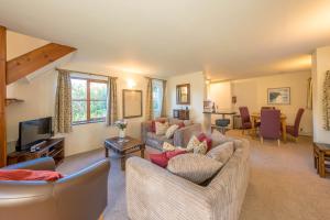 a living room with two couches and a television at Gwyddfid-Y-Ffynnon in Llanfyrnach