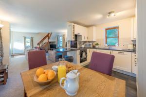 a kitchen with a wooden table with a bowl of oranges at Gwyddfid-Y-Ffynnon in Llanfyrnach