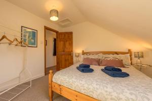 a bedroom with a bed with blue towels on it at Gwyddfid-Y-Ffynnon in Llanfyrnach