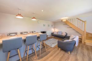 LlanerchymeddにあるBwthyn-Pili-Palaのテーブルと椅子のあるキッチンとリビングルーム