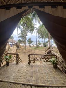 a tent with a table and benches on a beach at MORE Beach in El Nido