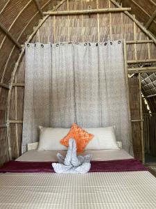 a bed in a tent with a stuffed animal on it at MORE Beach in El Nido +14 photos