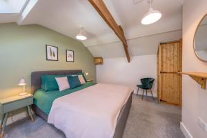 LlanerchymeddにあるBwthyn-Pili-Palaのベッドとテーブルと鏡のある寝室