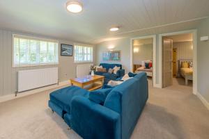 a living room with two blue couches in a room at Ffawydd-Y-Ffynnon in Llanfyrnach