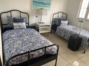 a bedroom with two beds and a suitcase at Family Beach House with an Amazing Ocean View in Naguabo +25 photos