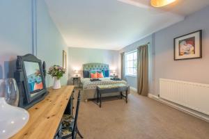 a bedroom with a bed and a tv in a room at Eiddew-Y-Ffynnon in Llanfyrnach
