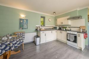 a kitchen with a table and a dining room at Eiddew-Y-Ffynnon in Llanfyrnach +15 photos