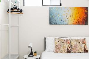 a bedroom with a bed with a painting on the wall at Relaxed Private Double Room in Carramar - Close to Station - Shared Bathroom in Villawood